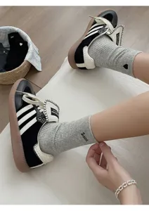 Close-up detail of crew socks with heart embroidery and stylish letter design worn with sneakers.