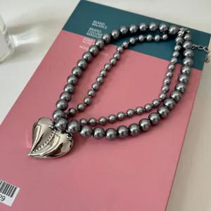 Collier de perles grises à double rang avec pendentif cœur argenté pour femmes élégantes.
