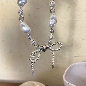 Chique parel strik telefoonhanger kralen ketting, elegante mobiele accessoire met kristal.