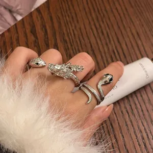 Primer plano detallado de anillos apilables de tendencia plateados dragón y serpiente.