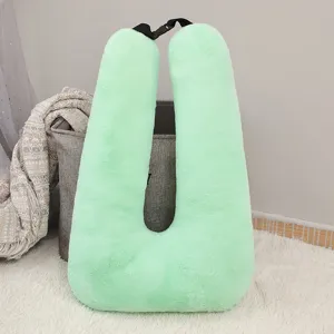Green plush U-shaped travel pillow with strap, comfortable neck support for car and office use.