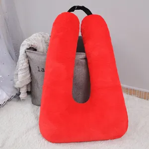 Red plush U-shaped travel pillow car cushion with black buckle strap for comfortable resting.