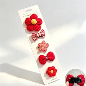 Dettaglio set fermagli per animali con fiori rossi e fiocchi su cartoncino con clip.
