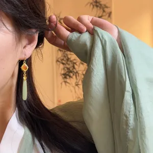 Detail shot of new Chinese style vintage jade drop metal long earrings worn by model.