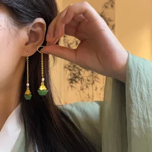 Detailed close-up view of traditional chinese style tassel earrings with jade bells detail shot.