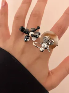 Detailed shot of unique Y2K beaded flower and silver flask rings, perfect for stacking.
