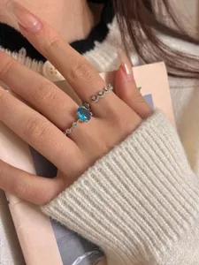 Detail view of a gorgeous blue oval gemstone ring stacked with a delicate sparkling diamond band.