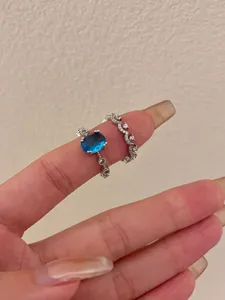 Stunning oval blue gemstone and sparkling rhinestone crown ring detail closeup fashion jewelry