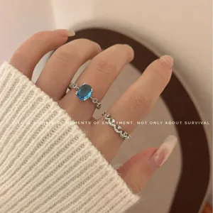 Oval blue topaz gemstone ring and shimmering diamond crown ring set for women, elegant jewelry.