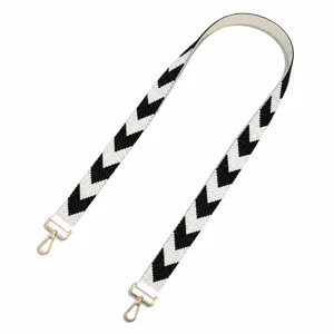 Black and white beaded bag strap detail, geometric chevron woven pattern with gold metal clasps.