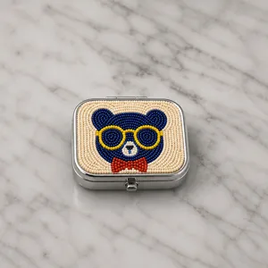 Gros plan détaillé du motif d'ours en perles avec lunettes de soleil sur boîte en métal.