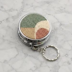 Détail boîte à pilules en métal et perles, pendentif porte-clés géométrique portable.