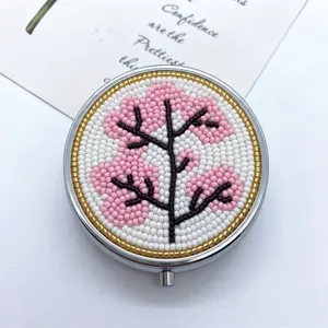 Handgefertigter Perlen-Taschenspiegel mit filigranem rosa-weißem Blumenbaum-Design.