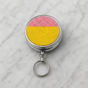 Porte-clés pilulier en métal perlé, boîte de rangement portable rose et jaune vif.