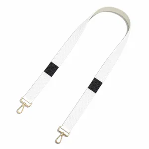 Detailed view of white beaded wide bag strap with black geometric pattern and gold clasps.