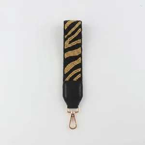 Perlen Handschlaufe Schlüsselanhänger Detail mit schwarz-goldenen Perlen und Karabinerhaken.