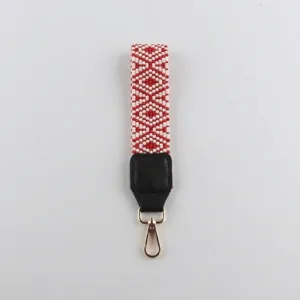 Detailansicht des handgefertigten rot-weißen Perlen-Armbands mit goldenem Verschluss und Lederpart.