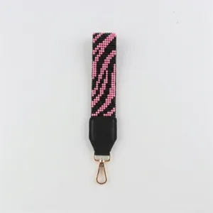 Detailaufnahme des Perlen-Handgelenkrihmens mit schwarz-rosa Zebramuster und goldenem Verschluss.