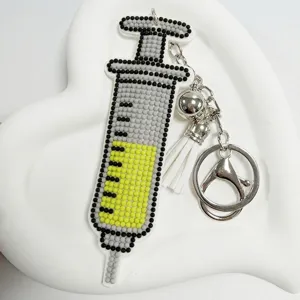 Detailansicht eines Spritzen Strass Schlüsselanhängers mit Quaste und Glocke, handgemacht.