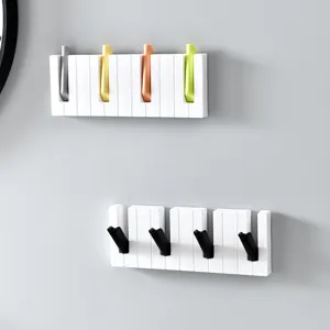 Wall-mounted piano key coat hook, creative plastic wall organizer for hats, bags, and umbrellas.