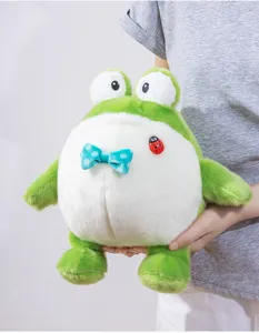 Primo piano del simpatico peluche rana verde paffuto con fiocco blu e dettaglio coccinella.