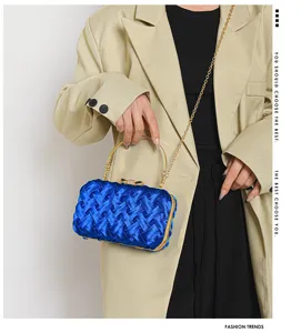 Dettaglio borsa sera raso intrecciato blu, manico metallo e catena per stile di lusso.