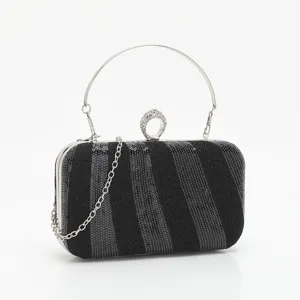 Black sequined evening clutch bag with rhinestone ring handle and silver chain strap for party.