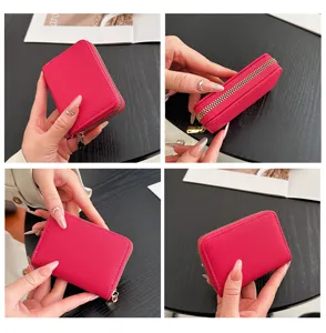 Vue en gros plan des détails du portefeuille zippé en cuir PU rose vif accordéon.