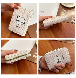 Vue détaillée d'un porte-cartes matelassé pour femme avec imprimé d'ours et fermeture éclair.