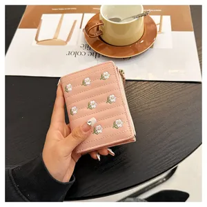 Close-up of pink short wallet with floral embroidery, zipper pocket and multi-card slots.