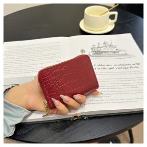 Detail view of a stylish red crocodile pattern women coin purse and card holder with zipper.