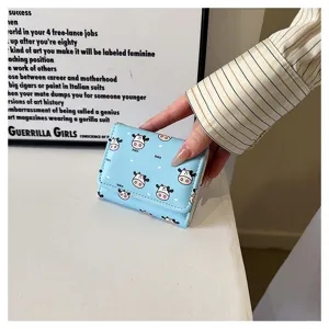 Detailed view of the cute light blue trifold wallet with charming cow pattern for women.