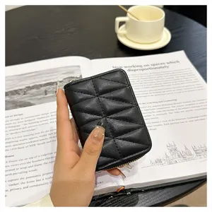 Detailed view of black quilted leather card holder with zip closure and accordion compartments.