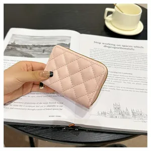 Close-up view of a pink quilted card holder wallet with zipper, showing fine texture and details.