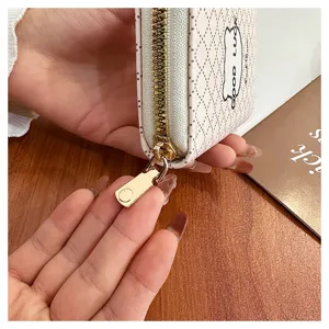 Gros plan détaillé du porte-cartes compact pour femme avec motif d'ours et fermeture éclair.
