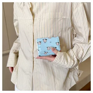 Compact light blue trifold wallet with cute cartoon cow pattern, perfect for daily use.