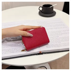 Monedero tarjetero con cremallera de cuero rojo compacto con múltiples ranuras.