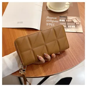 Brown quilted long wallet detail showing zipper closure, triangle pattern and wrist strap.