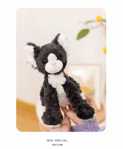 Black and white cat plush toy detail view, showing soft fluffy texture and cute embroidered face.