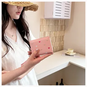 Close-up view of the pink pu leather wallet showcasing delicate embroidered heart details.