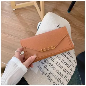 Detail view of a brown long wallet with elegant envelope flap and metallic clasp decoration.