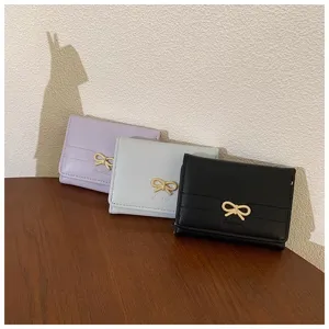 Detail view of cute short wallet featuring delicate bowknot metal decor in three chic colors.