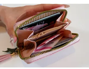 Women's pink short PU leather zipper coin purse and card holder with cute tassel detail.