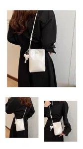 Detail view of the cute mini crossbody phone bag with an adorable elephant charm pendant.