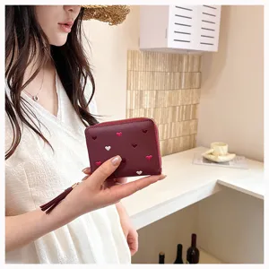 Close-up view of the cute red PU leather coin purse with heart embroidery and tassel detail.