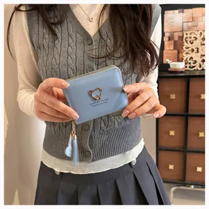 Cute light blue short wallet detail view featuring a metal bear charm and a tassel pendant.