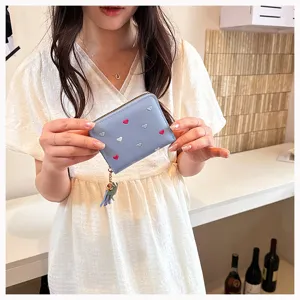 Detailed view of a cute blue PU leather short wallet featuring colorful embroidered hearts and tassel.