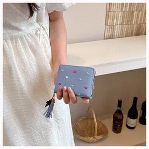 Close-up view of a blue PU leather short wallet featuring cute embroidered hearts and tassel.
