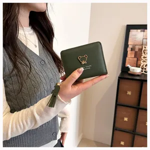 Short green women's wallet with cute bear emblem and tassel. Compact zipper purse for daily use.