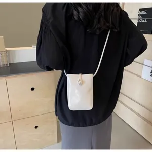 Minimalist white phone crossbody bag for women with elegant pearl button and slim strap.